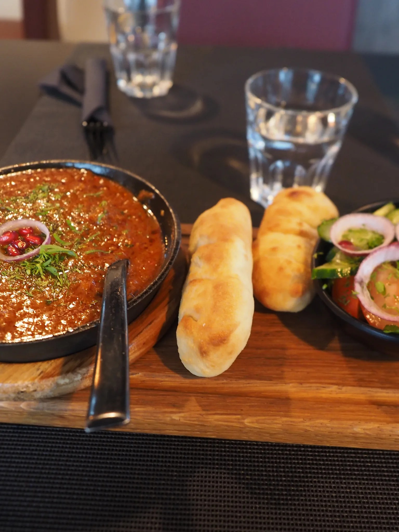 chashushuli: A dish of Chashushuli (Georgian spicy beef stew), bread and Georgian-style salad, along with a glass of water, served at restaurant Rioni in Haukilahti, Espoo, Finland