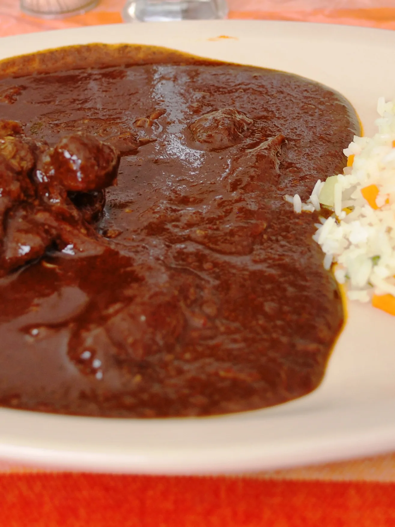 Mole poblano: Chicken thigh in red mole sauce served with rice. At a restaurant in Taxco de Alarcón, Guerrero, Mexico