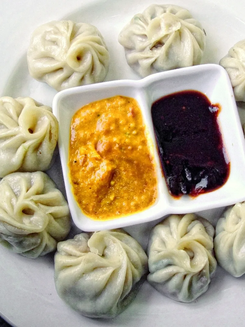 Momo: A typical serving of a plate of Momo with Sesame Yellow Sauce and Red Ginger Chilli Sauce in Nepal