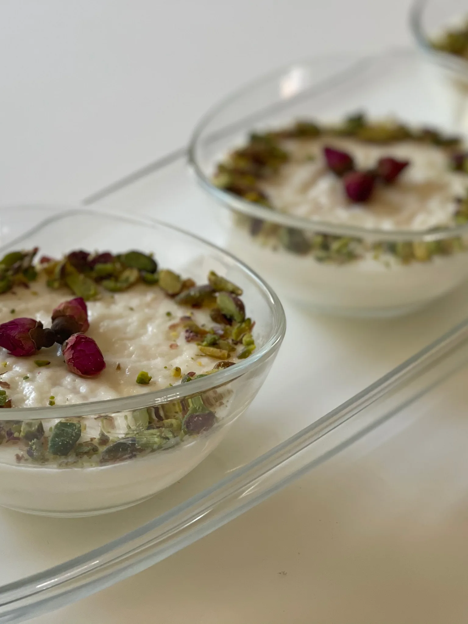 mehallabiyya: Mhallabiyyeh (a variation of Arabic milk pudding) decorated with pistachios and rose petals. Made with semolina seeds and rose water