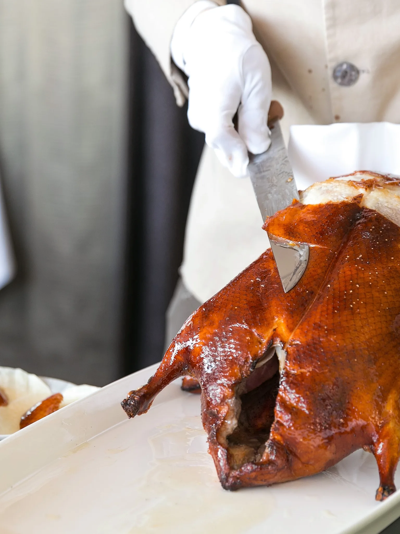 Peking duck: Tranchieren einer gebackenen Pekingente am Tisch des Gastes im Restaurant Yan Toh Heen im Hotel InterContinal Hong Kong in Hongkong, hier beim Abschneiden der Haut in Rauten